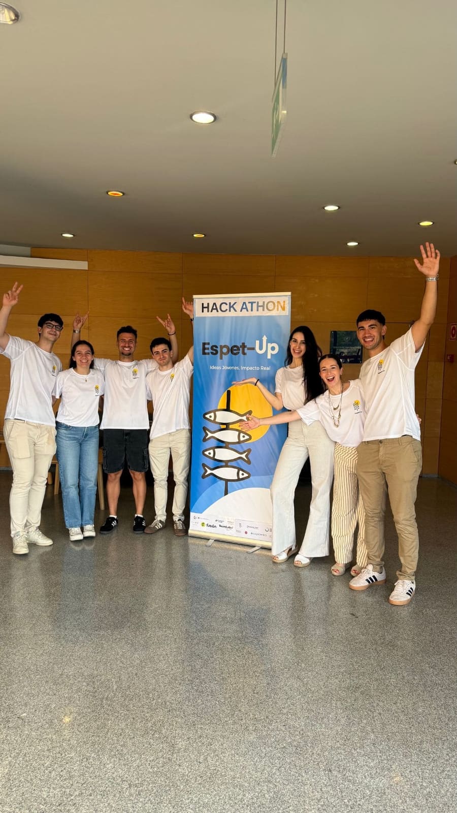 El equipo de Espet-Up, con camisetas blancas, celebra junto al roll-up del Hackathon