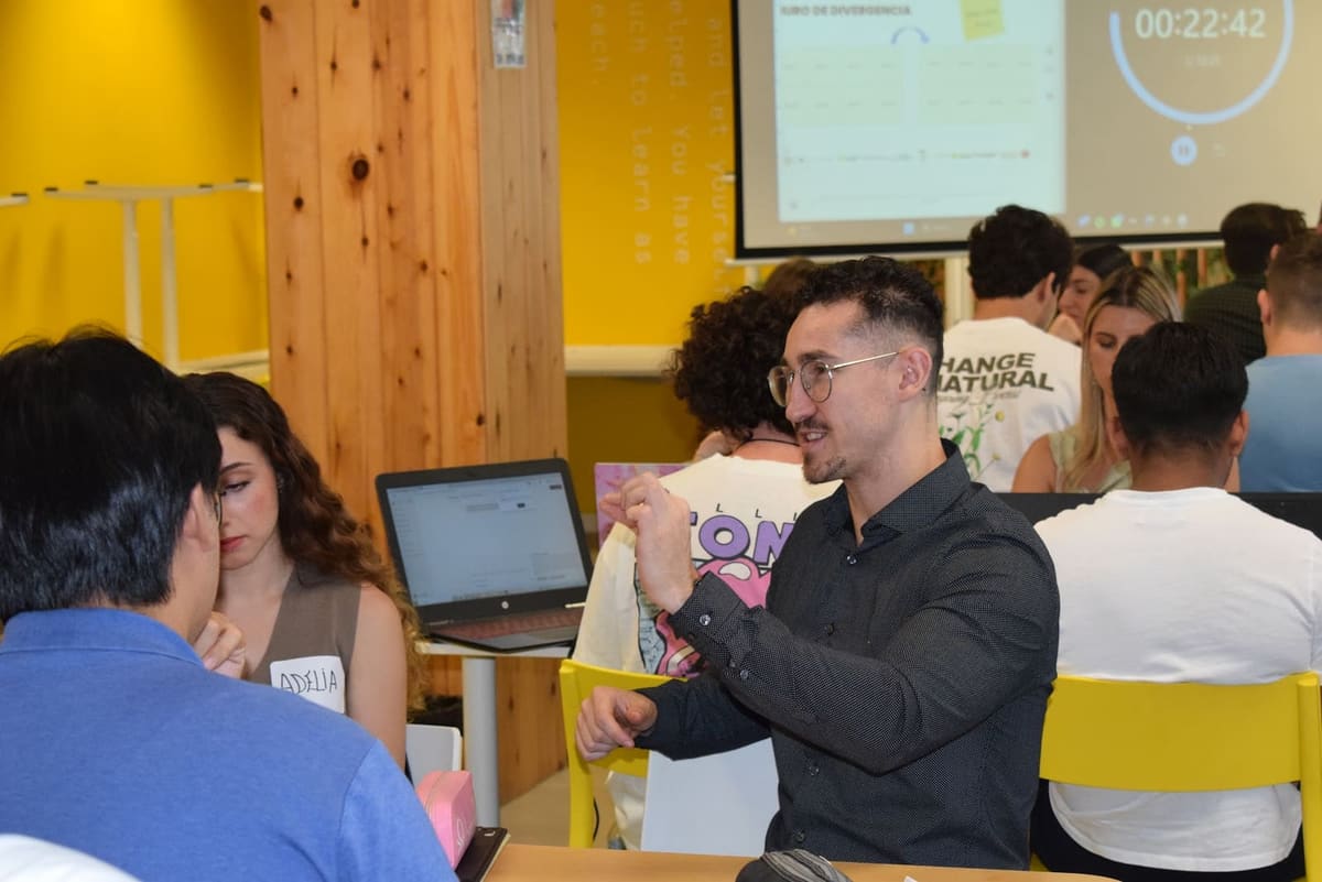 Un mentor revisa con un equipo su proyecto en el portátil durante el Hackathon Espet-Up