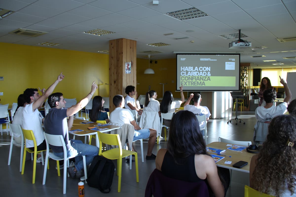 Sala llena del taller de oratoria con Silvina Hood, con varias personas levantando la mano